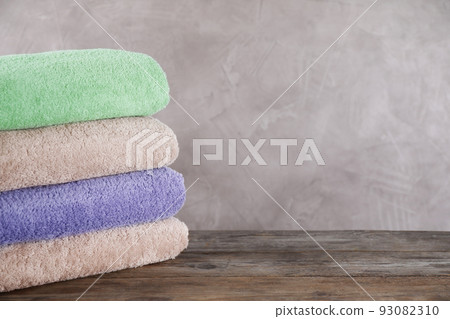 Stack of clean bath towels on wooden table. Space for text 93082310