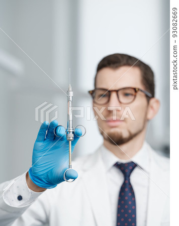 Closeup shot of syringe in hands of a male doctor Closeup shot of syringe in hands of a male doctor 93082669