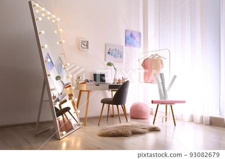 Large mirror with light bulbs in stylish room interior 93082679