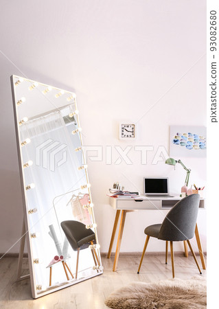 Large mirror with light bulbs in stylish room interior 93082680