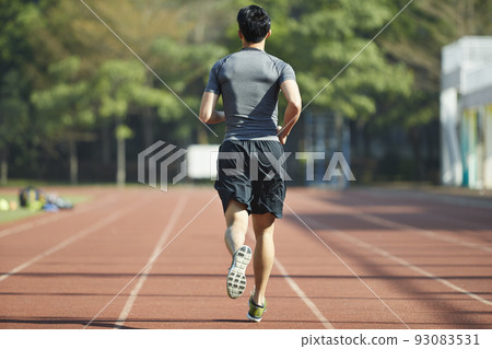 young asian man male athlete running training exercising on track, rear view 93083531