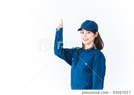 A young woman wearing work clothes and pointing with a smile A young woman wearing work clothes and pointing with a smile 93087017