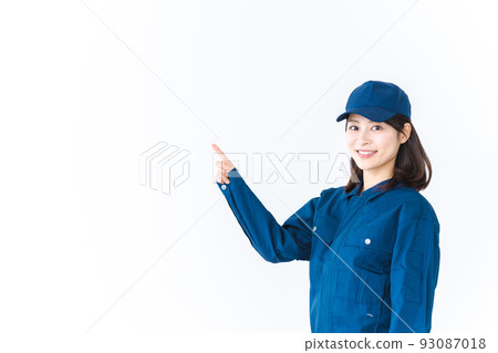 A young woman wearing work clothes and pointing with a smile A young woman wearing work clothes and pointing with a smile 93087018
