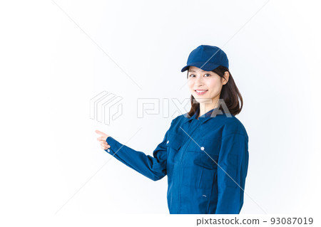A young woman wearing work clothes and pointing with a smile A young woman wearing work clothes and pointing with a smile 93087019