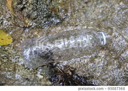 A plastic bottle thrown away in a stream 93087368