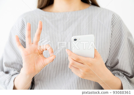 一個十幾歲的年輕女人拿著智能手機 93088361
