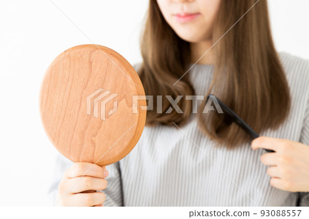 Young woman combing her long hair 93088557