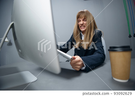 Evil irritated millennial blonde businesswoman worker in blue jacket breaks keyboard hate operation crash in gray modern office. Remote Job, Technology And Career Profession Concept. Wide angle Evil irritated millennial blonde businesswoman worker in blue jacket breaks keyboard hate operation crash in gray modern office. Remote Job, Technology And Career Profession Concept. Wide angle 93092629