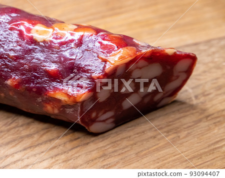 Smoked sausage on a wooden cutting board, food close-up shot. Tasty sausage. Smoked sausage on a wooden cutting board, food close-up shot. Tasty sausage. 93094407