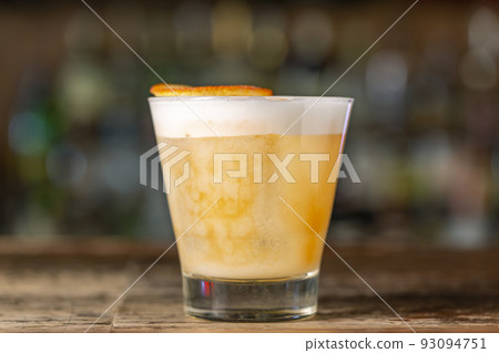 Vanilla Sour cocktail with egg white and lemon juice  on the bar. 93094751