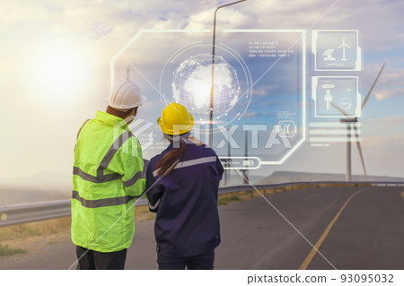 Young maintenance engineer team working in wind turbine farm at sunset on interface data. 93095032