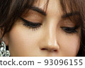 Beautiful macro shot of female eye with classic eyeliner makeup. Perfect shape of eyebrows, brown eyeshadows and long eyelashes. Cosmetics and make-up. Closeup macro shot of fashion liner eyes visage 93096155