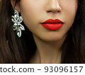 Close-up of woman's lips with fashion bright pink make-up. Beautiful female mouth, full lips with perfect makeup. Part of female face. Choice lipstick. Red wavy hair of a doll 93096157