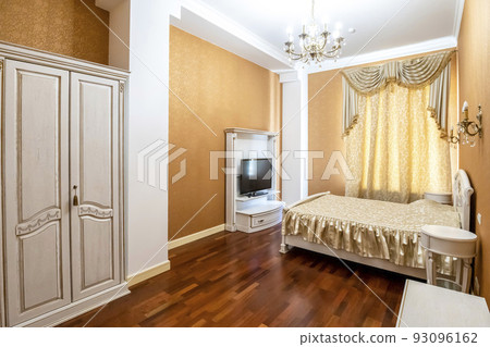 Bedroom with a large bed and a TV in front of it Bedroom with a large bed and a TV in front of it 93096162