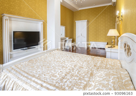 Bedroom with a large bed and a TV in front of it Bedroom with a large bed and a TV in front of it 93096163