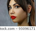 Beautiful brunet model woman face with green eyes and perfect make-up make smile on camera. Portrait of beauty with red lips and eyes liner, thick eyesbrow . Female face with clear skin close-up. 93096171