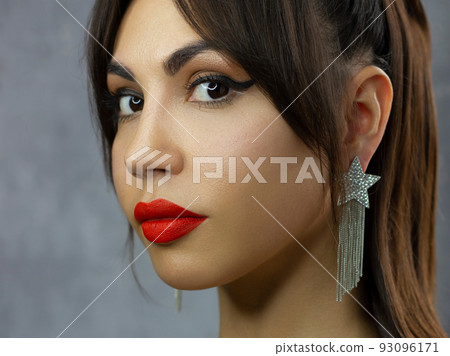 Beautiful brunet model woman face with green eyes and perfect make-up make smile on camera. Portrait of beauty with red lips and eyes liner, thick eyesbrow . Female face with clear skin close-up. 93096171