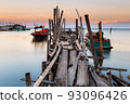Old wood bridge for small fishing boat in the sea with sunset 93096426