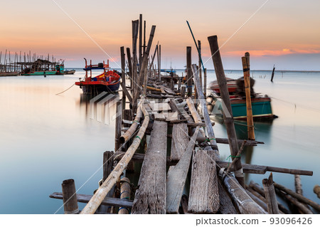 Old wood bridge for small fishing boat in the sea with sunset Old wood bridge for small fishing boat in the sea with sunset 93096426