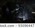 Industrial worker is welding automotive part in factory 93096447