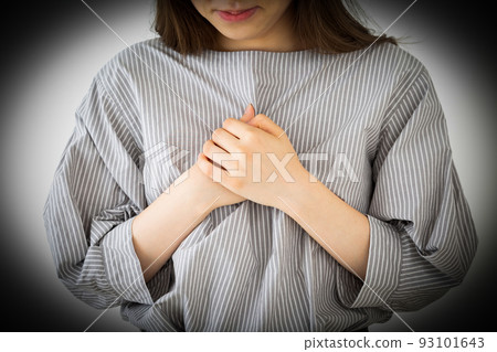 Young woman holding her chest in pain 93101643