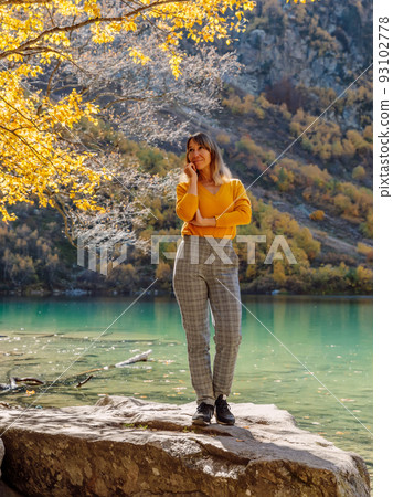 Beauty woman at transparent lake in the autumnal mountains. Lake and hiker lady Beauty woman at transparent lake in the autumnal mountains. Lake and hiker lady 93102778