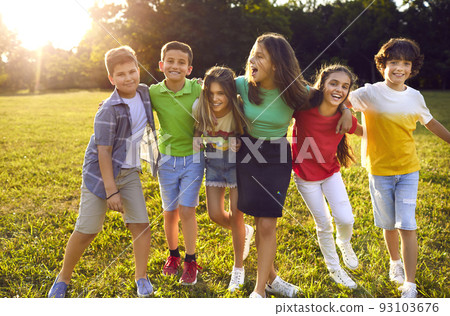 Group of happy cheerful little children walking in green park and hugging each other Group of happy cheerful little children walking in green park and hugging each other 93103676