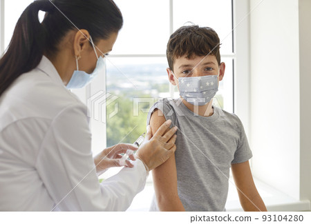 School boy in medical face mask getting vaccine that will protect him during pandemic 93104280