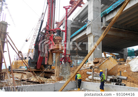 KUALA LUMPUR, MALAYSIA -MARCH 30, 2022: Bore pile rig machine at the construction site. The machine used to driven pile for building foundation work. Operated by skilled workers. KUALA LUMPUR, MALAYSIA -MARCH 30, 2022: Bore pile rig machine at the construction site. The machine used to driven pile for building foundation work. Operated by skilled workers. 93104416