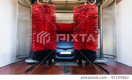 Car washing machine. Auto brush washer clean blue car on automatic carwash station. Automated car washing machine background. 93104862