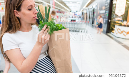 Woman food shopping pregnancy. Pregnant mother with healthy lettuce salad leaves, fresh tomato in market food bag on grocery supermarket background. Healthy food background. Woman food shopping pregnancy. Pregnant mother with healthy lettuce salad leaves, fresh tomato in market food bag on grocery supermarket background. Healthy food background. 93104872