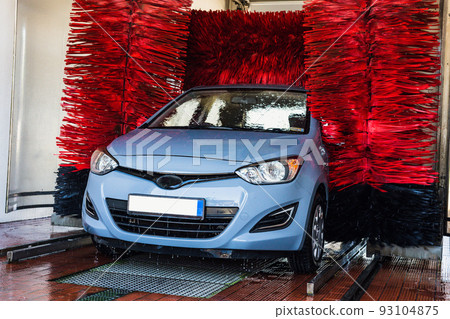 Car washing automatic carwash. Brush washer clean blue auto car on automatic car wash station. Carwash cleaning service. Car washing automatic carwash. Brush washer clean blue auto car on automatic car wash station. Carwash cleaning service. 93104875