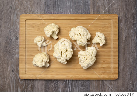 Cauliflower inflorescences on a kitchen board Cauliflower inflorescences on a kitchen board 93105317
