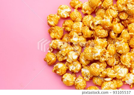 Honey caramel popcorn on pink background. Honey caramel popcorn on pink background. 93105537