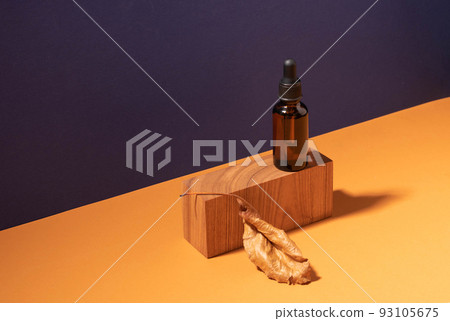Cosmetic dropper bottle on a creative modern podium. Brown background with hard shadows, copy space 93105675