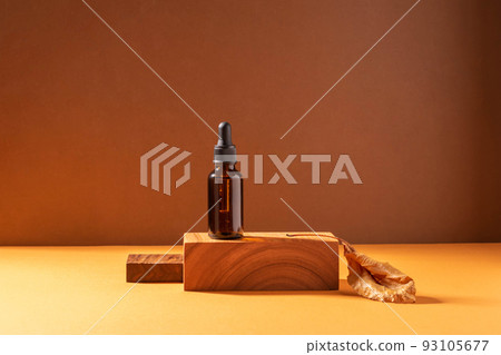 Cosmetic dropper bottle on a creative modern podium. Brown background with hard shadows, copy space 93105677
