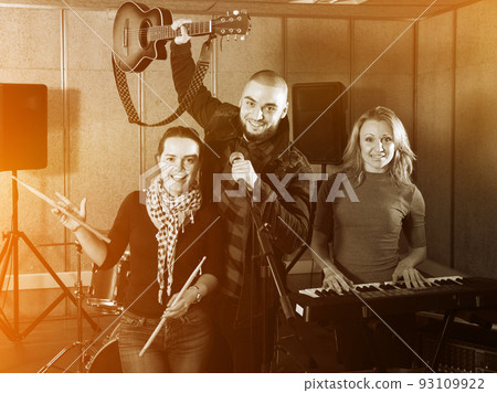 expressive group of rock musicians posing with instruments 93109922