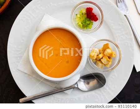 Cold soup gazpacho in bowl served with vegetables and baked breads. Spanish cuisine Cold soup gazpacho in bowl served with vegetables and baked breads. Spanish cuisine 93110140