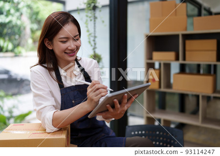 Attractive Asian entrepreneur business woman checking order by tablet 93114247