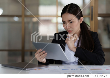 Image of Asian Business woman stressed while analyzing financial report balance. Financial and investment concept. 93114473