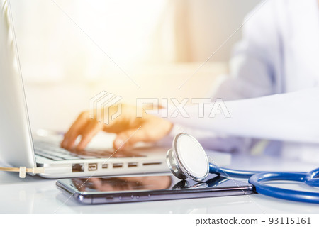 Doctor woman typing information of patient prescription from paperwork medical history form into laptop 93115161