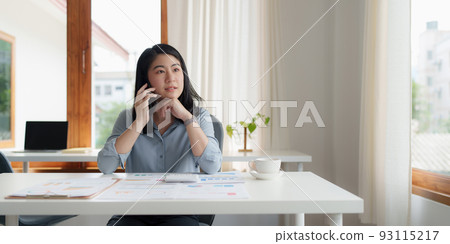 Portrait of Asian Business woman at work talking on phone. Finance Concept. 93115217