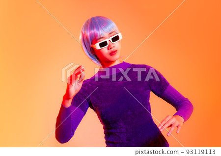 Young asian woman acting robot in purple dress wearing white sunglasses posing on the orange background. Future cyborg girl and metaverse concept Young asian woman acting robot in purple dress wearing white sunglasses posing on the orange background. Future cyborg girl and metaverse concept 93119113
