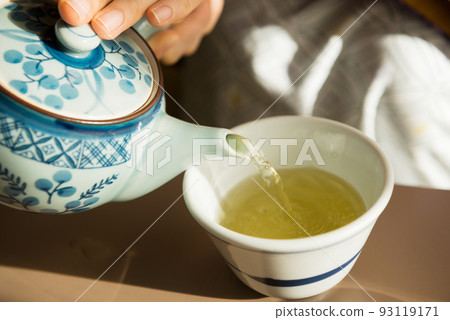 A woman putting tea 93119171
