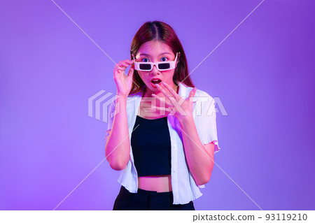 Young asian woman in black tank top and white shirt wearing sunglasses posing wow and surprised isolated purple color background Young asian woman in black tank top and white shirt wearing sunglasses posing wow and surprised isolated purple color background 93119210