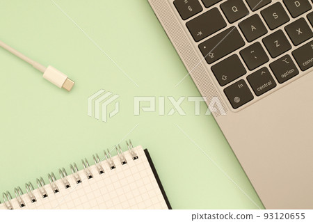 notebook, white usb c cable and laptop on green background notebook, white usb c cable and laptop on green background 93120655
