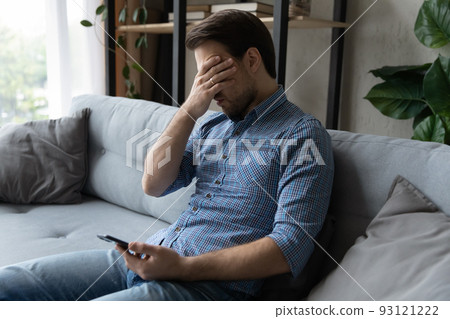 Sad man holds smartphone suffering from relations break up message Sad man holds smartphone suffering from relations break up message 93121222