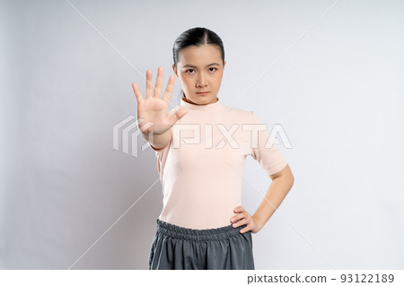 Asian woman showing hand making stop sign. Asian woman showing hand making stop sign. 93122189