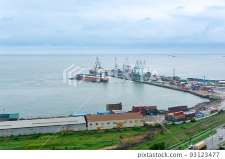 aerial view of the container cargo terminal of the port of Korsakov on Sakhalin, Russia, with a container ship moored with the help of tugs 93123477