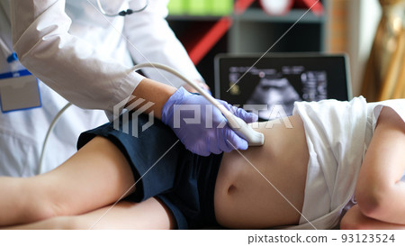 Doctor making examining with ultrasound of internal organs of child in clinic office 93123524